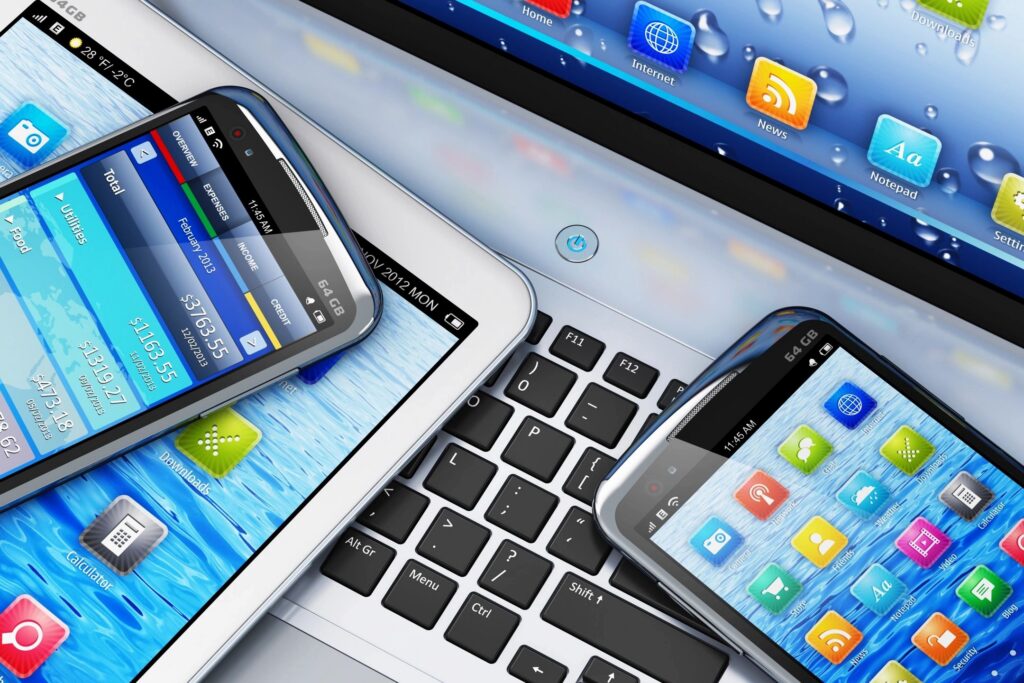 Smartphones and tablets stacked on a laptop keyboard